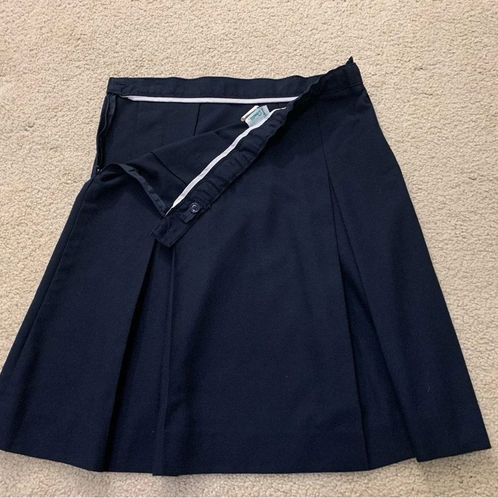 Navy blue pleated skirt with adjustable waist.